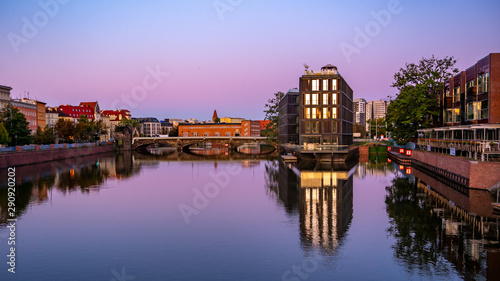 The river Odra at sunrise with modern building in Wroclaw, Poland. Viwe from university bridge.