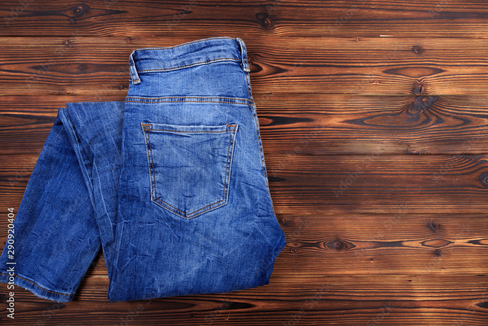 blue denim jeans on wooden background . blue denim jeans on wooden background .