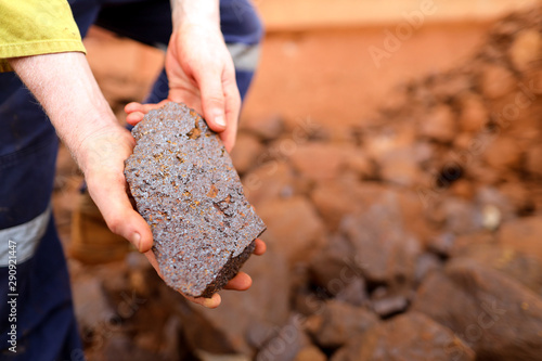 Close up picture of scientist geologist hands inspecting exploration on iron ore rock on open field mine site, Perth, Australia  photo