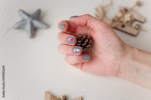 female hands with christmas deer manicure on the finger nails photo