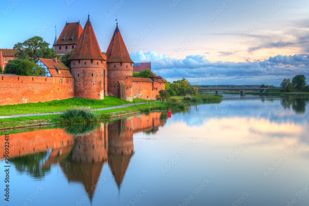 Fototapeta premium Malbork castle over the Nogat river at sunset, Poland