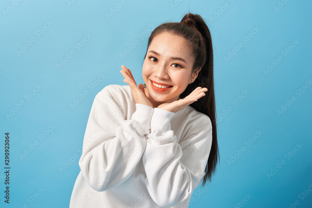 Portrait of joyful carefree adorable adult woman smiling broadly and holding palms near cheeks, being playful and emotive with positive attitude to life Portrait of joyful carefree adorable adult woman smiling broadly and holding palms near cheeks, being playful and emotive with positive attitude to life