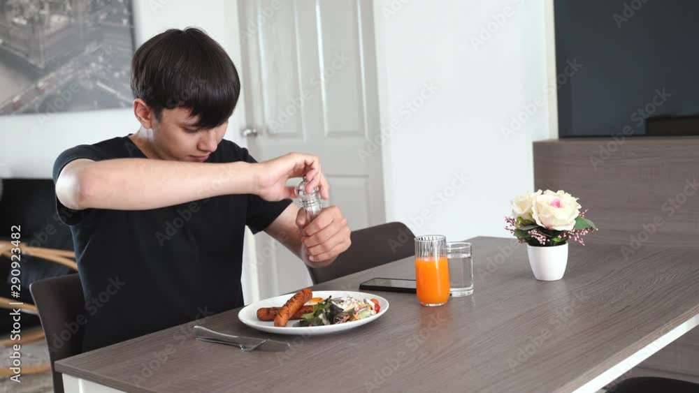 Young mixed race millennial man eating healthy breakfast and taking photo from smartphone in his apartment, lifestyle and eating concept Young mixed race millennial man eating healthy breakfast and taking photo from smartphone in his apartment, lifestyle and eating concept