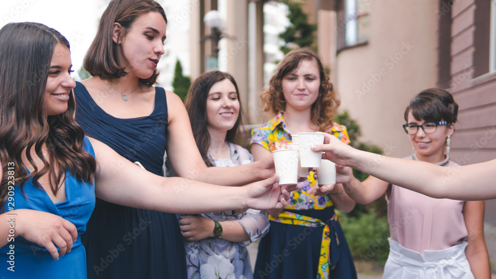 Group of girlfriends toasting with champagne in paper glass. Young people celebrating with champagne at party outdoors. Concept of hen-party Group of girlfriends toasting with champagne in paper glass. Young people celebrating with champagne at party outdoors. Concept of hen-party