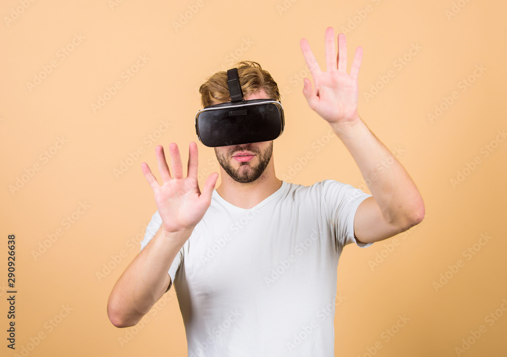 Virtual simulation. VR for gaming. Man play game in VR glasses. Explore cyber space. Man hipster with virtual reality headset on peach background. Entertainment and education. Virtual communication Virtual simulation. VR for gaming. Man play game in VR glasses. Explore cyber space. Man hipster with virtual reality headset on peach background. Entertainment and education. Virtual communication