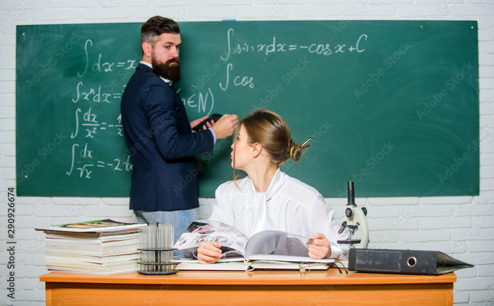 College university education. High school. Solving task. Man writing on chalkboard math formulas. Teaching in university. University education. Knowledge transfer. Teacher and student near chalkboard