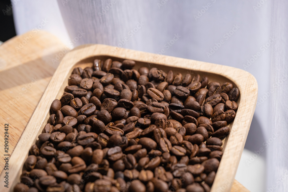 Fototapeta premium coffee beans and wooden plate on the table near the window