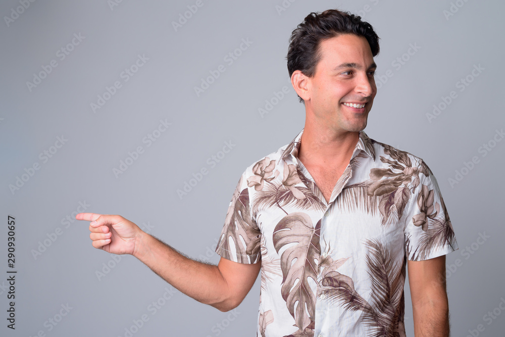 © Ranta Images - Portrait of happy handsome Hispanic tourist man pointing finger while looking away © Ranta Images - Portrait of happy handsome Hispanic tourist man pointing finger while looking away