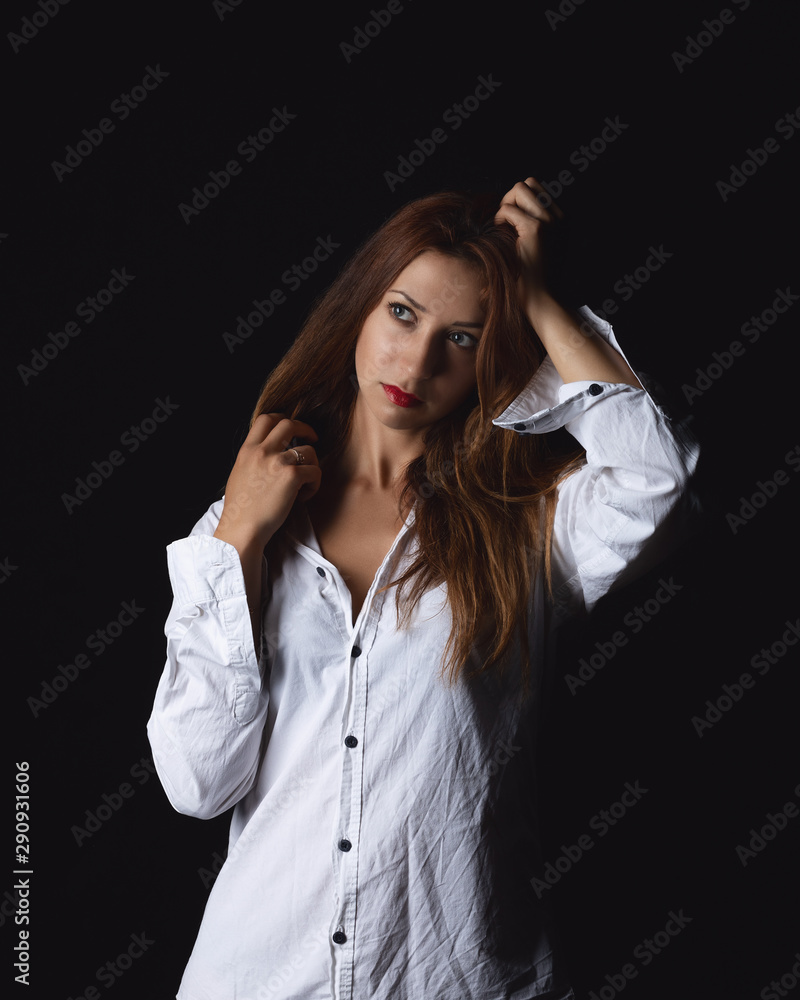 attractive beautiful athletic girl model in white shirt sitting isolated on black background in photo studio attractive beautiful athletic girl model in white shirt sitting isolated on black background in photo studio
