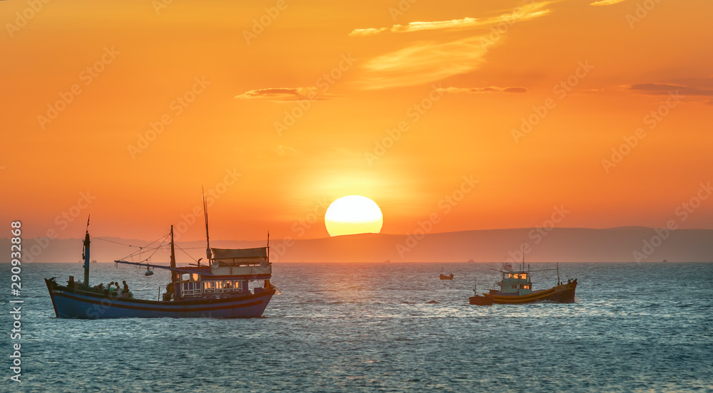 Fototapeta premium Sea landscape at sunset when fishing boats out to sea to harvest fish end the day.