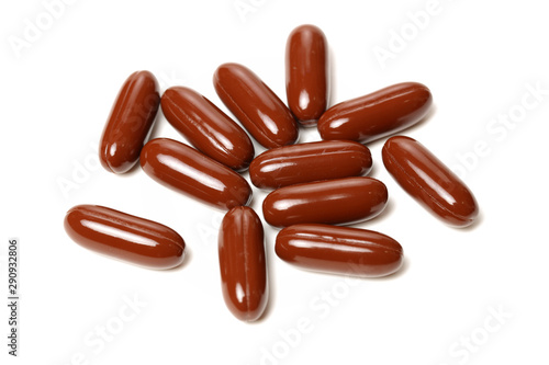 Red brown large vitamin pills on a white background.
