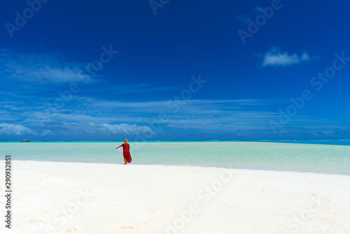 Woman in a red dress on the beach  Aitutaki island  Cook Islands  South Pacific. Copy space for text.