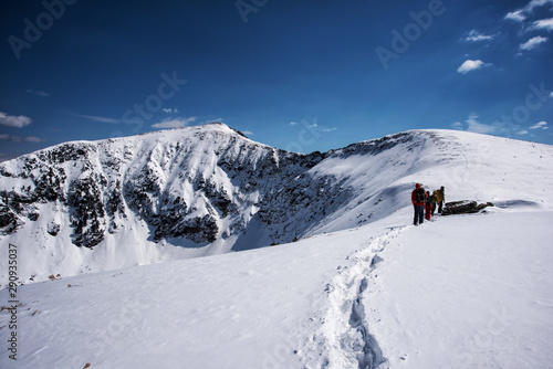 Irkutsk region, Russia, Slyudyanka - April 13, 2019: Group of people are hiking in the mountain and snow among the fir trees back view