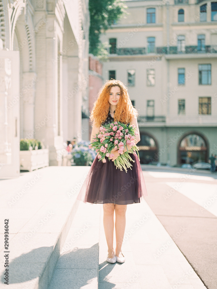 Fototapeta premium young beauty woman with flower buquet on the spring street. film analog photography