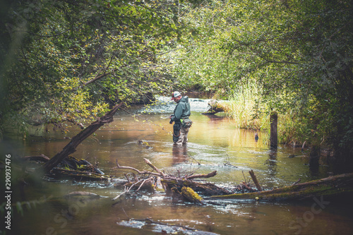 A fisherman catches spinning in the waders. Trout fishing.