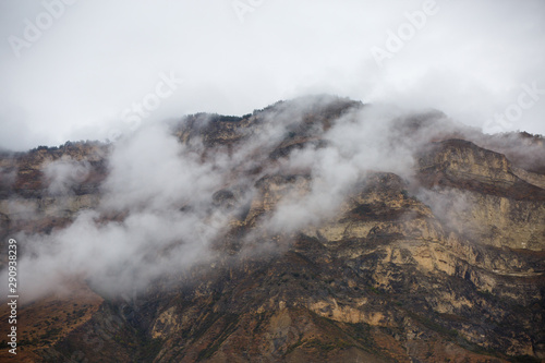 Image of mountains with green vegetation, smoke above tops