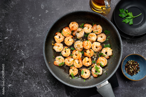 Top view of fried prawns in a pan on black table