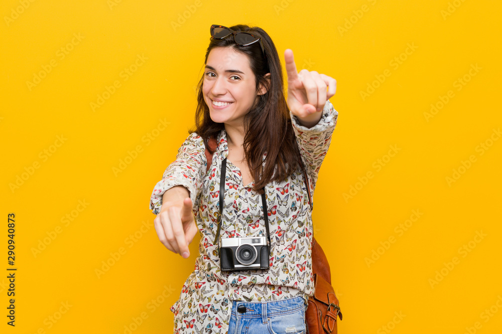 Young brunette traveler woman cheerful smiles pointing to front. Young brunette traveler woman cheerful smiles pointing to front.