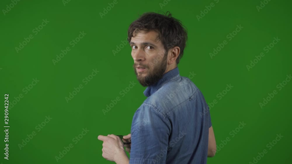 Happy young brunette man turning around and looking into a camera. on the green screen. Happy young brunette man turning around and looking into a camera. on the green screen.