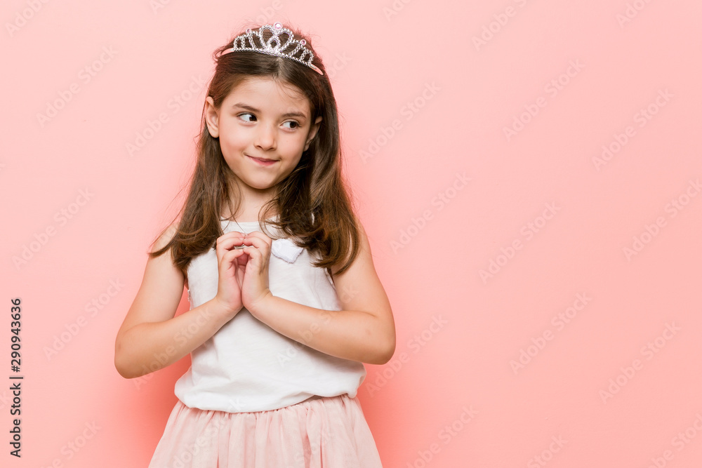 Little girl wearing a princess look making up plan in mind, setting up an idea. Little girl wearing a princess look making up plan in mind, setting up an idea.
