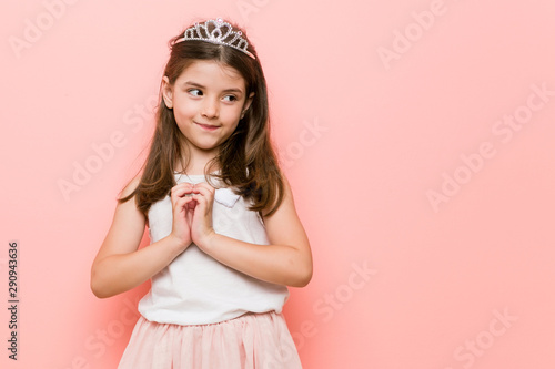 Little girl wearing a princess look making up plan in mind, setting up an idea.