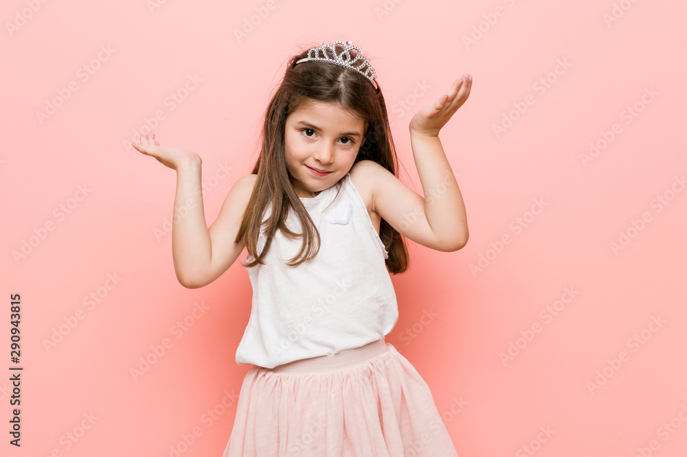 Little girl wearing a princess look makes scale with arms, feels happy and confident. Little girl wearing a princess look makes scale with arms, feels happy and confident.