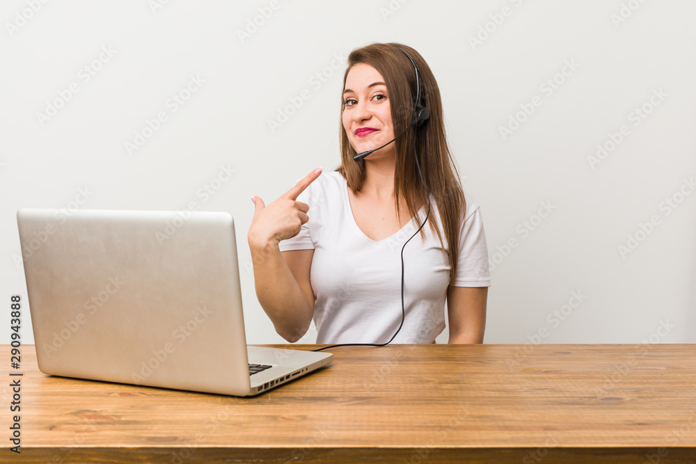 Young telemarketer woman pointing with finger at you as if inviting come closer.