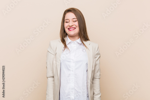 Young business woman laughs and closes eyes, feels relaxed and happy.