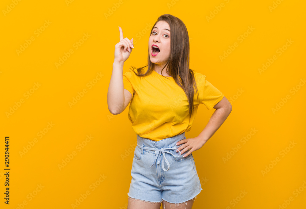 Young woman teenager wearing a yellow shirt having an idea, inspiration concept. Young woman teenager wearing a yellow shirt having an idea, inspiration concept.