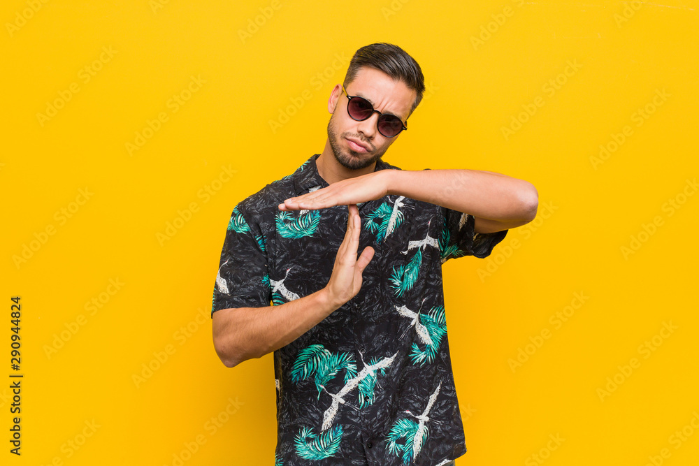 Young filipino man wearing summer clothes showing a timeout gesture. Young filipino man wearing summer clothes showing a timeout gesture.