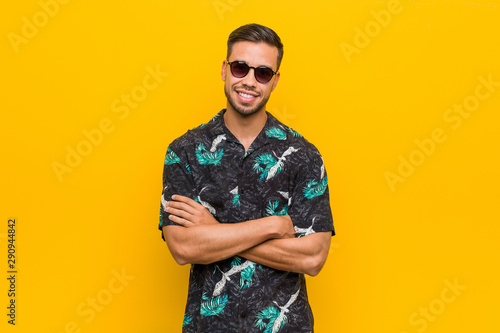 Young filipino man wearing summer clothes who feels confident, crossing arms with determination.