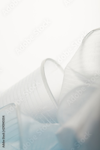 close up view of crumpled transparent disposable cups on white background