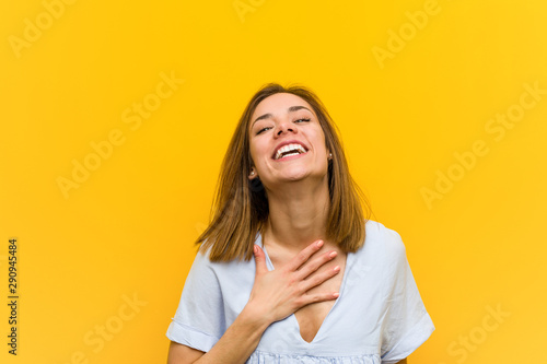Vászonkép Young pretty young woman laughs out loudly keeping hand on chest.