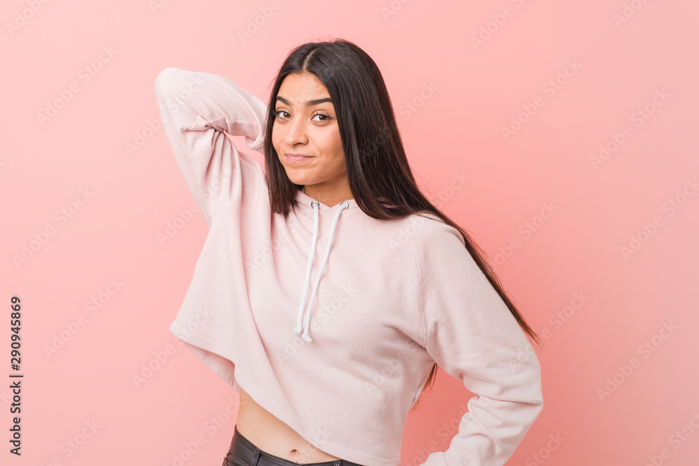 Obraz premium Young pretty arab woman wearing a casual sport look touching back of head, thinking and making a choice.