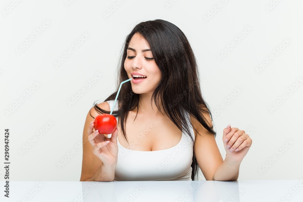 Young hispanic woman drinking a tomato juice with a straw Young hispanic woman drinking a tomato juice with a straw