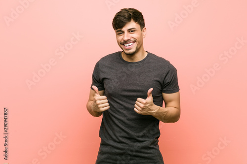 Young hispanic casual man raising both thumbs up, smiling and confident. photo
