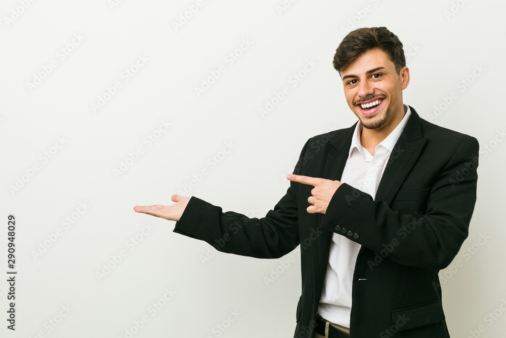 Young business hispanic man excited holding a copy space on palm. Young business hispanic man excited holding a copy space on palm.