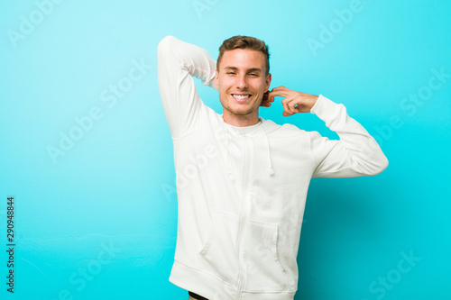 Young caucasian sport man stretching arms, relaxed position.