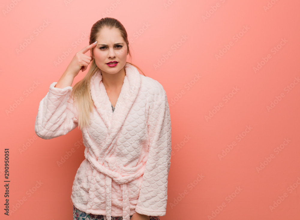Young russian woman wearing pajama doing a disappointment gesture with finger Young russian woman wearing pajama doing a disappointment gesture with finger