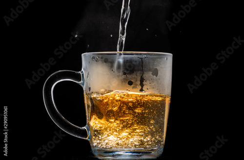 making black tea from a bag with sugar in motion on a black background
