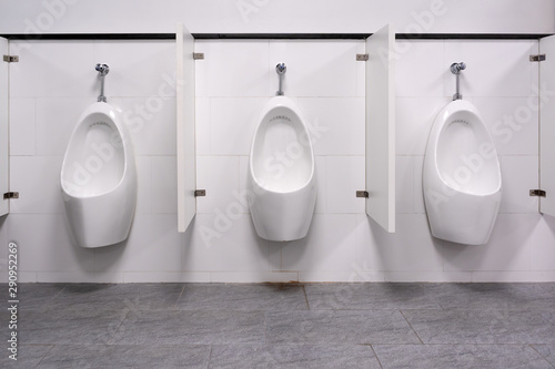 Row of white ceramic urinal chamber pot interior design with beautiful marble wall men public toilet or restroom