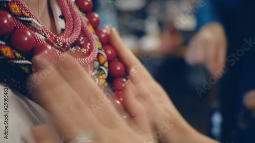Hands of the stylist puts jewelry on the neck of a fashionable girl. . multi-colored beads, Women's fashionable women, ethnic jewelry.slow motion photo