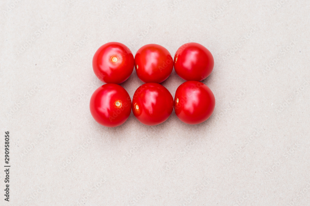Red cherry tomatoes on a kraft paper background. Small tomatoes. Red cherry tomatoes on a kraft paper background. Small tomatoes.