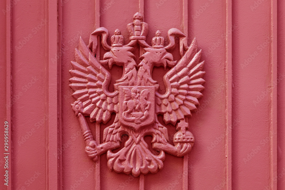 The coat of arms of the Russian Empire cast in metal painted red