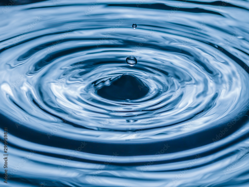 water drop splash in a glass blue colored water drop splash in a glass blue colored