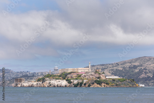 Close up of the Alcatraz island in San Francisco bay, under a blue sky with thick puffy clouds