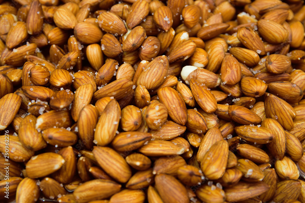 Peeled almond nuts with salt at the market close up Peeled almond nuts with salt at the market close up