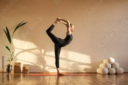 Obraz Piękna kobieta robi joga przy zmierzchu czasem w studiu