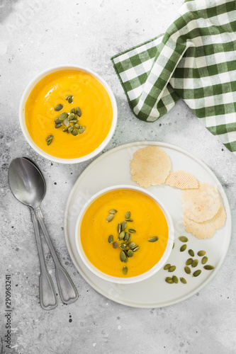 Autumn pumpkin cream soup with seeds. Light grey background