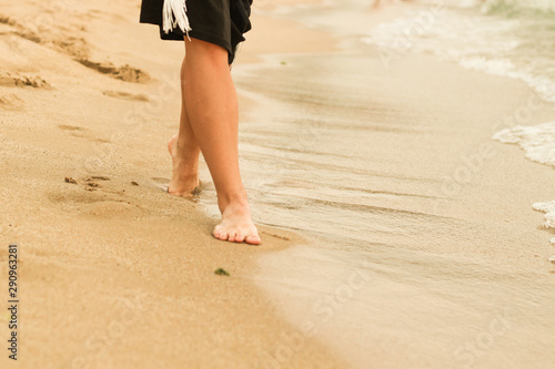 Female legs in the sand. Human foot. Sea. Advertising © Yaroslav